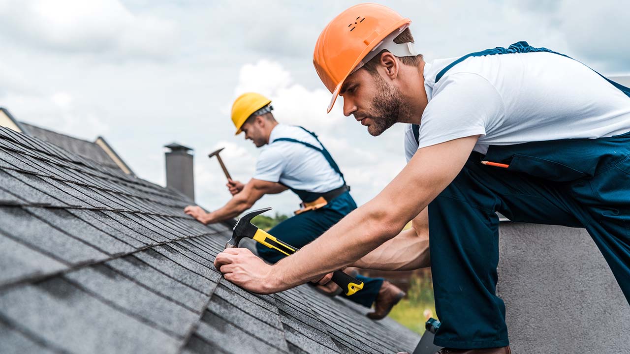 men working on a shingle rooftop